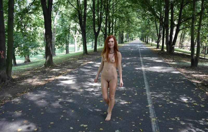 Голая женщина гуляет в парке