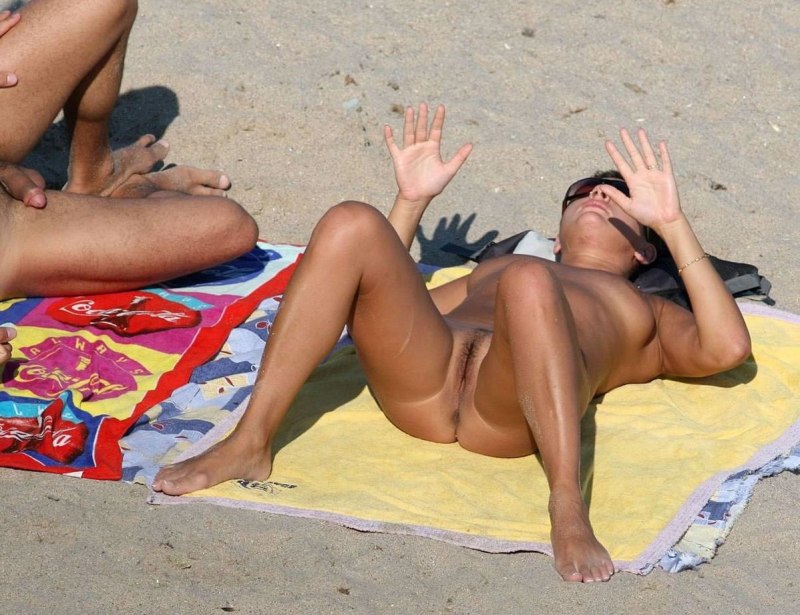 Нудистка загорает раздвинув ноги